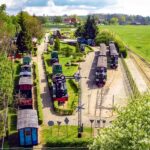 Widok z lotu ptaka na parowozy i wagony w Muzeum Kolei Wąskotorowej w Wenecji